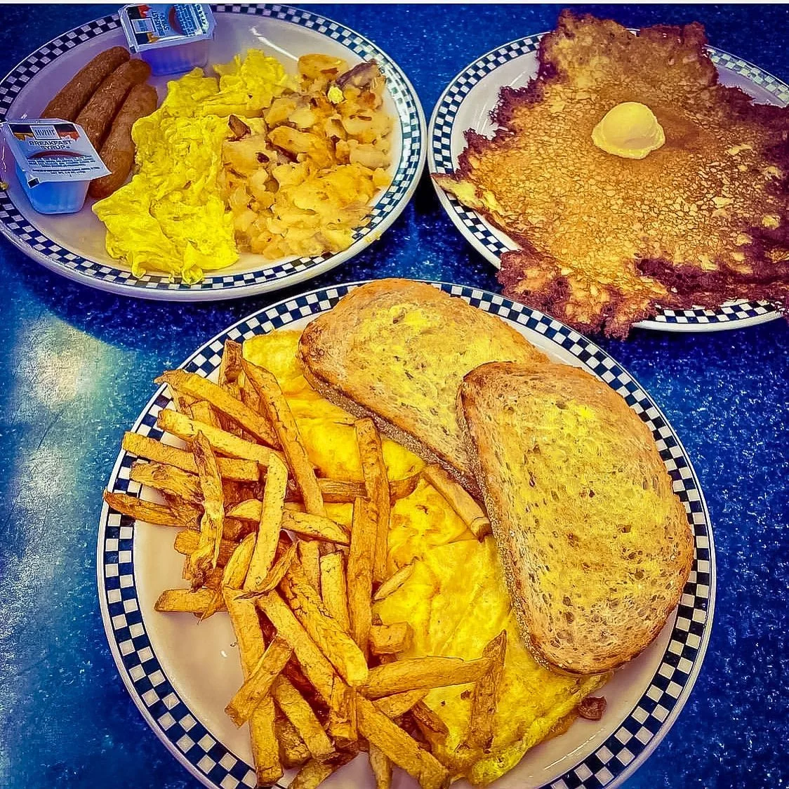 Diner breakfast plates with eggs, potatoes and hotcakes