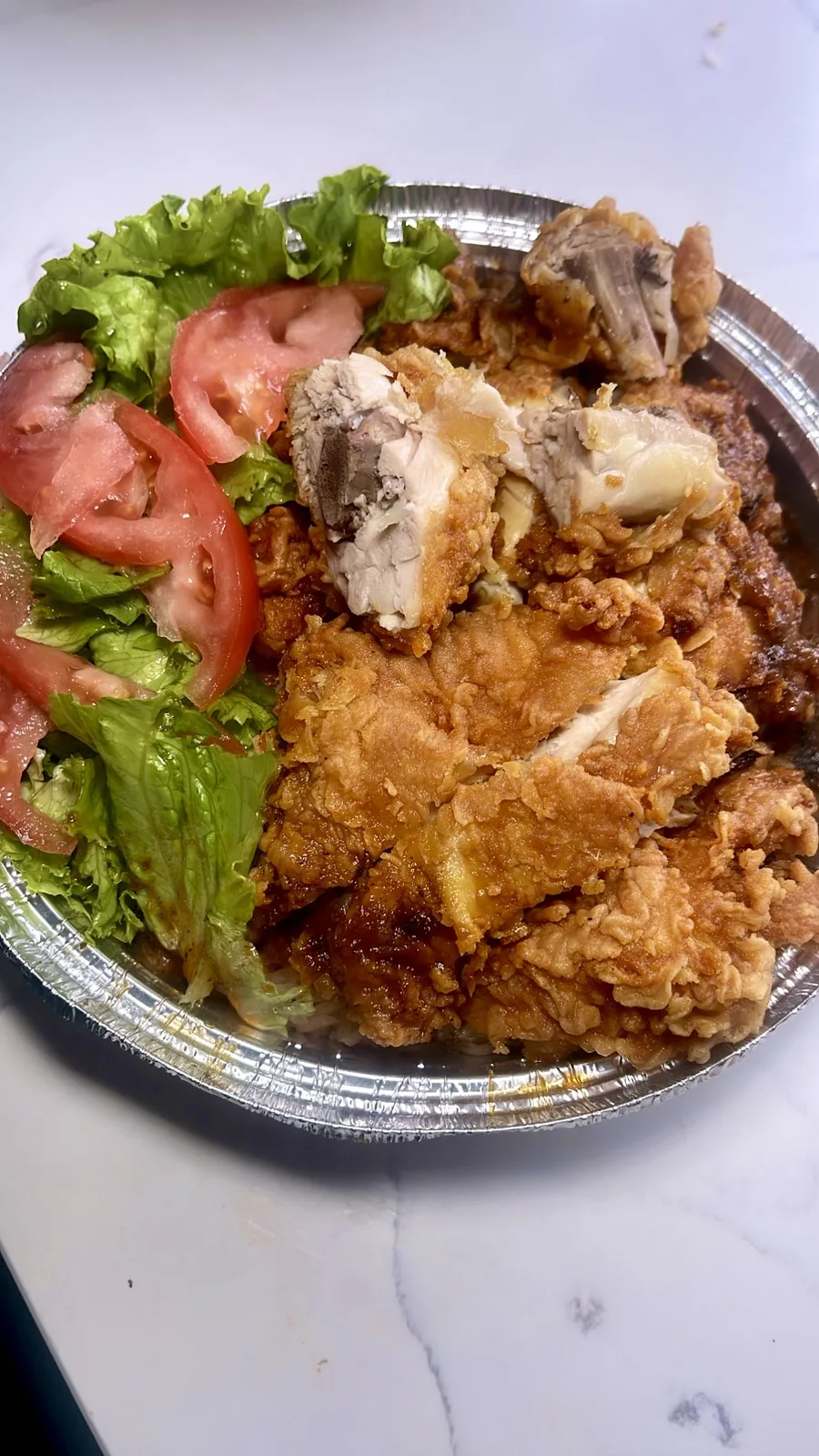 Chicken meal with rice and salad in a takeaway tray