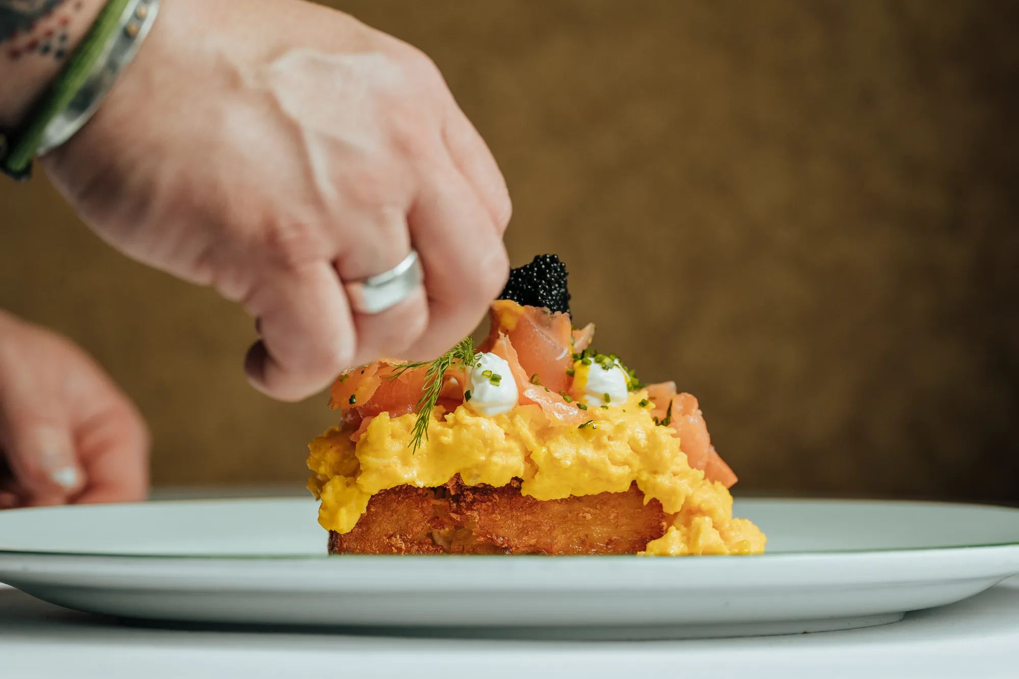 Chef garnishing a plated dish