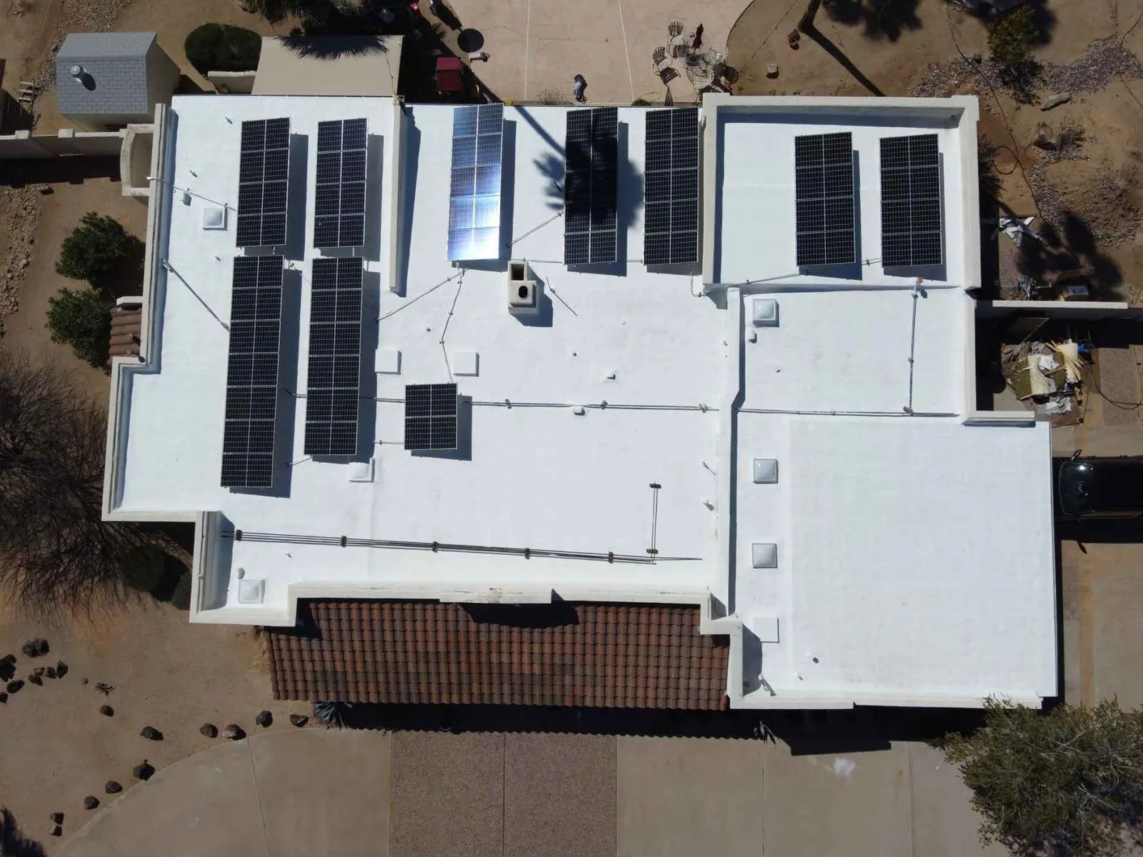 Aerial view of a flat residential roof with solar panels