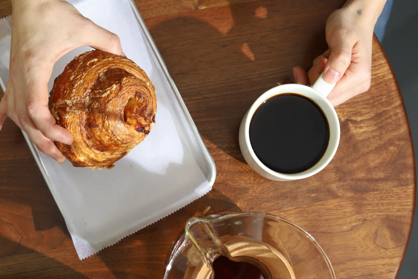 Coffee and a pastry on a wooden café table