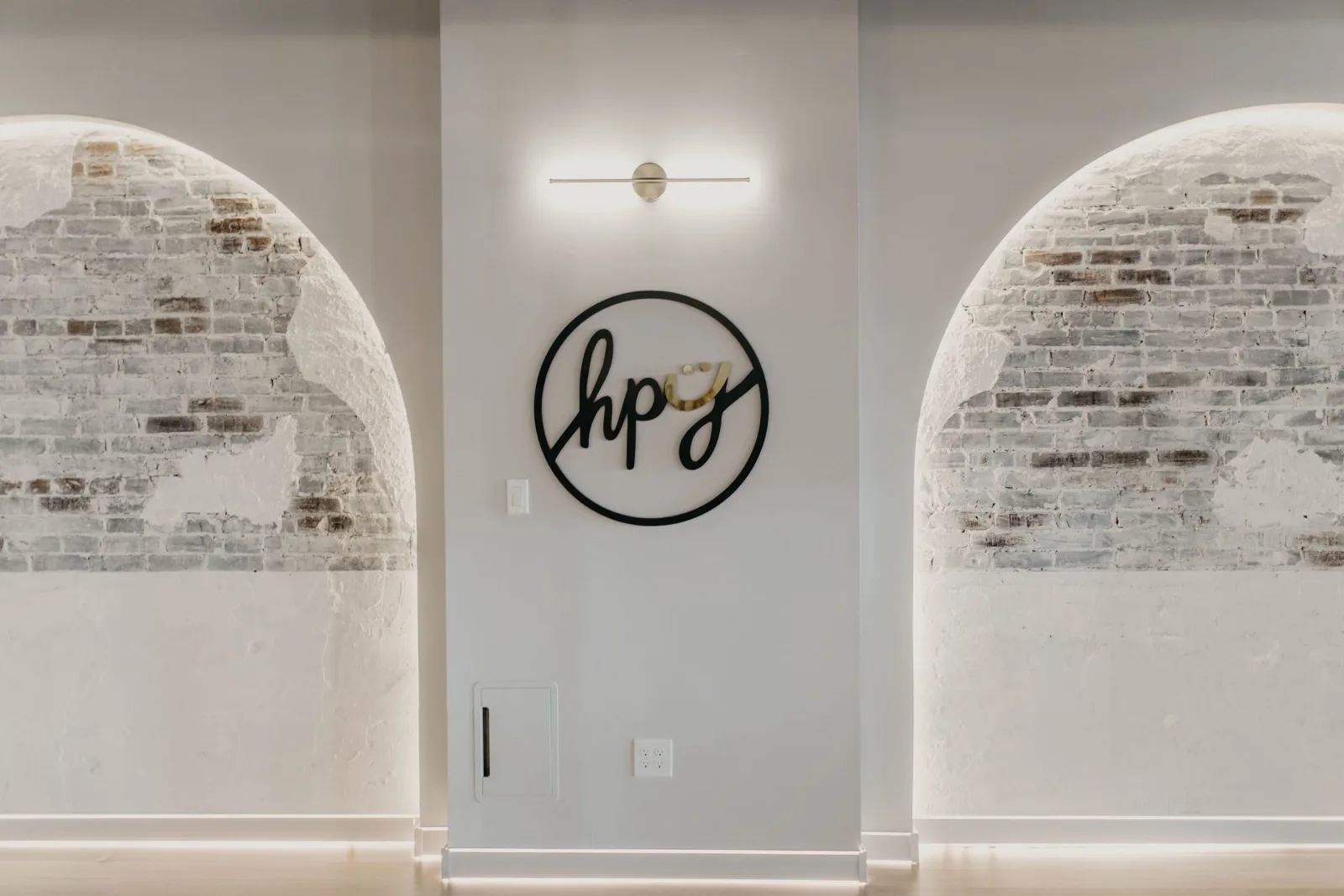 Brick arches and HPY wall sign inside the Graduate Hospital studio