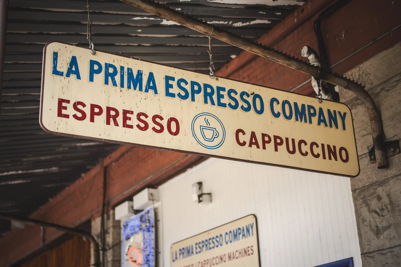 La Prima Espresso Company hanging sign outside a brick building