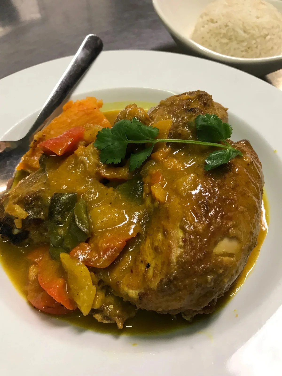 Chicken with curry sauce and sides on a plate