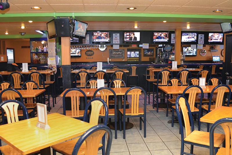 Empty dining tables and sports screens inside Pike Cafe