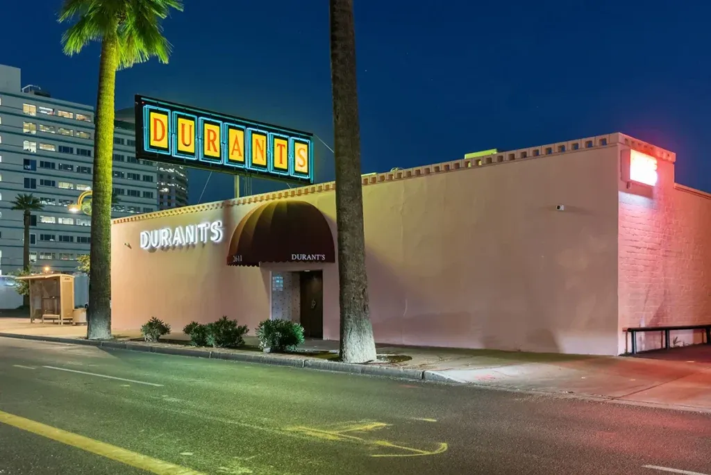 Durant's pink exterior and neon sign on Central Avenue at dusk