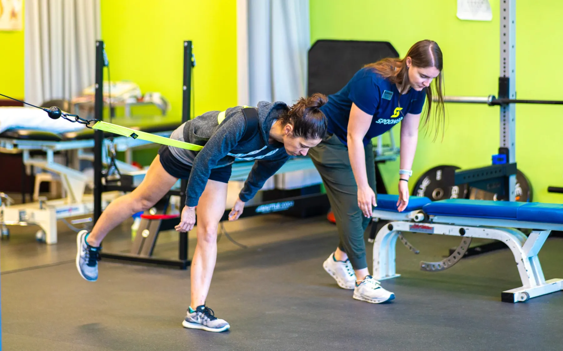 A physical therapist guiding a patient through a resistance-band exercise
