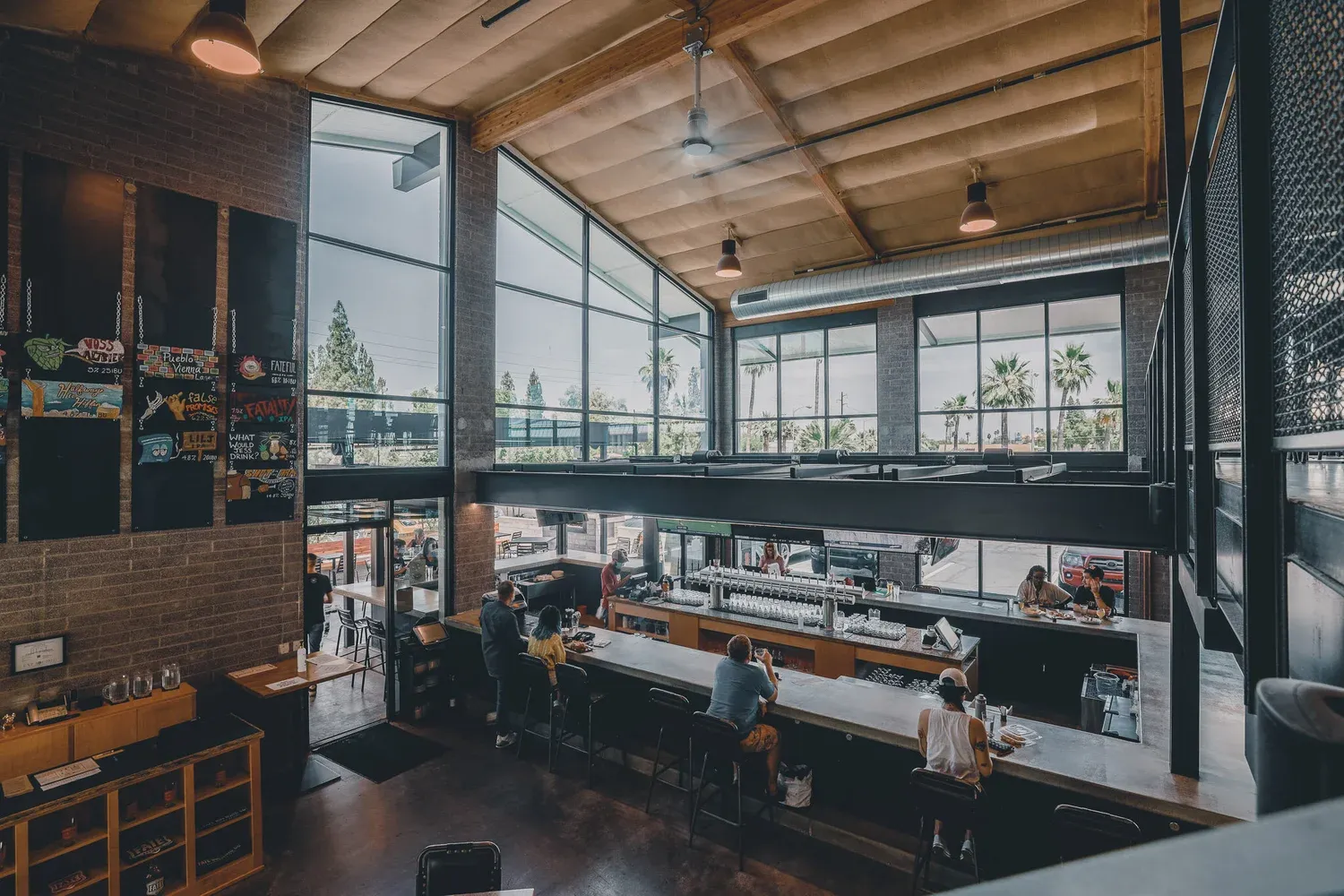Fate Brewing's bright taproom with tall windows and a long bar