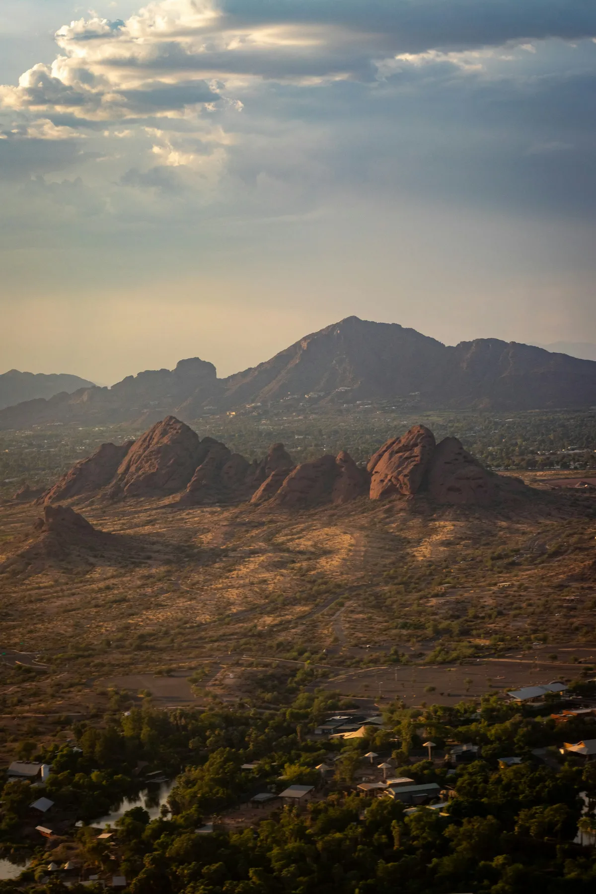 The red buttes of Papago Park with Camelback Mountain behind them under a cloudy sky