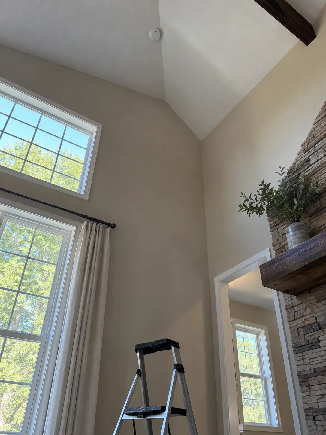 A smoke detector high on a tall vaulted ceiling