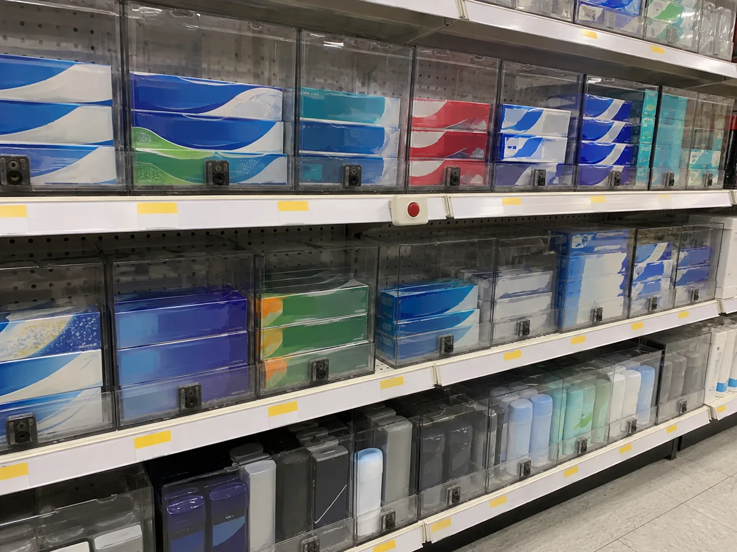 Store shelves of toothpaste locked behind clear plastic cases